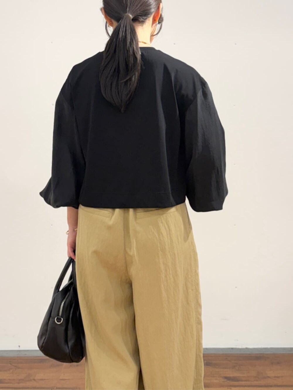 イエロー系のその他パンツ、ブラック系のTシャツ/カットソーを着用したレディースの夏コーディネートの6枚目の写真