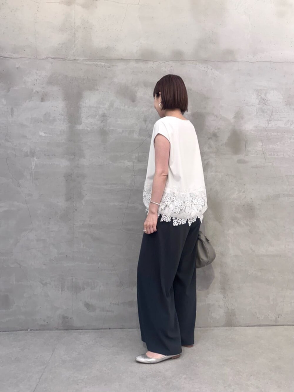 グレー系のその他パンツ、グレー系のボストンバッグ、ホワイト系のTシャツ/カットソーを着用したレディースの春コーディネートの3枚目の写真