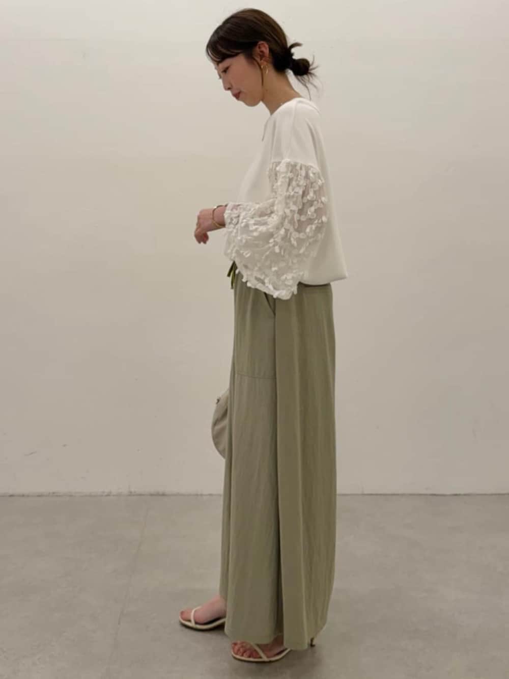 グレー系のボストンバッグ、グリーン系のその他パンツ、ホワイト系のTシャツ/カットソーを着用したレディースの春コーディネートの2枚目の写真