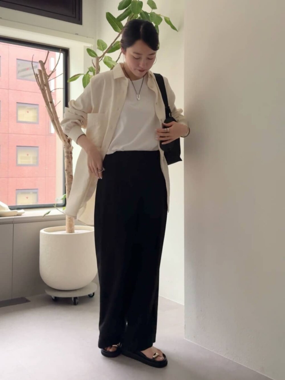 ブラック系のその他パンツ、ホワイト系のシャツ/ブラウス、ブラック系のサンダルを着用したレディースの冬コーディネートの2枚目の写真