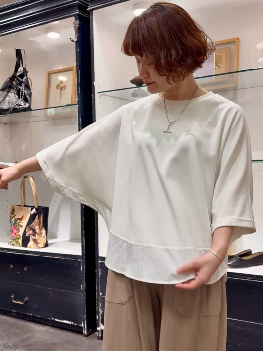 ベージュ系のその他パンツ、ブラック系のトートバッグ、ホワイト系のTシャツ/カットソーを着用したレディースの春コーディネートの6枚目の写真