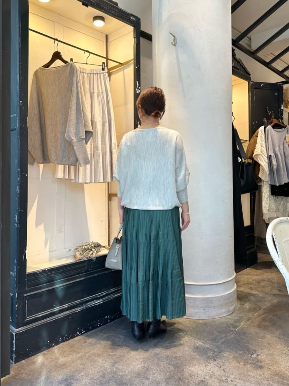 グリーン系のスカート、グレー系のニット/セーター、ブラック系のダウンジャケット/コートを着用したレディースの冬コーディネートの6枚目の写真