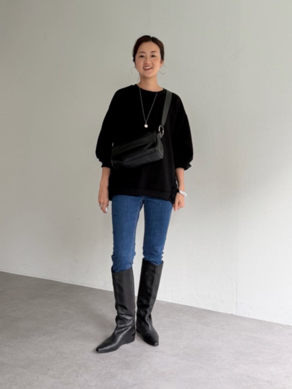 ブルー系のデニムパンツ、ブラック系のTシャツ/カットソーを着用したレディースの秋コーディネートの3枚目の写真