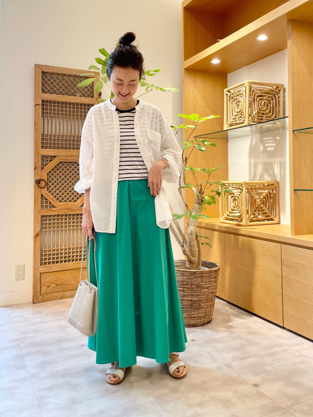 グリーン系のスカート、ホワイト系のシャツ/ブラウス、ホワイト系のTシャツ/カットソーを着用したレディースの夏コーディネートの2枚目の写真