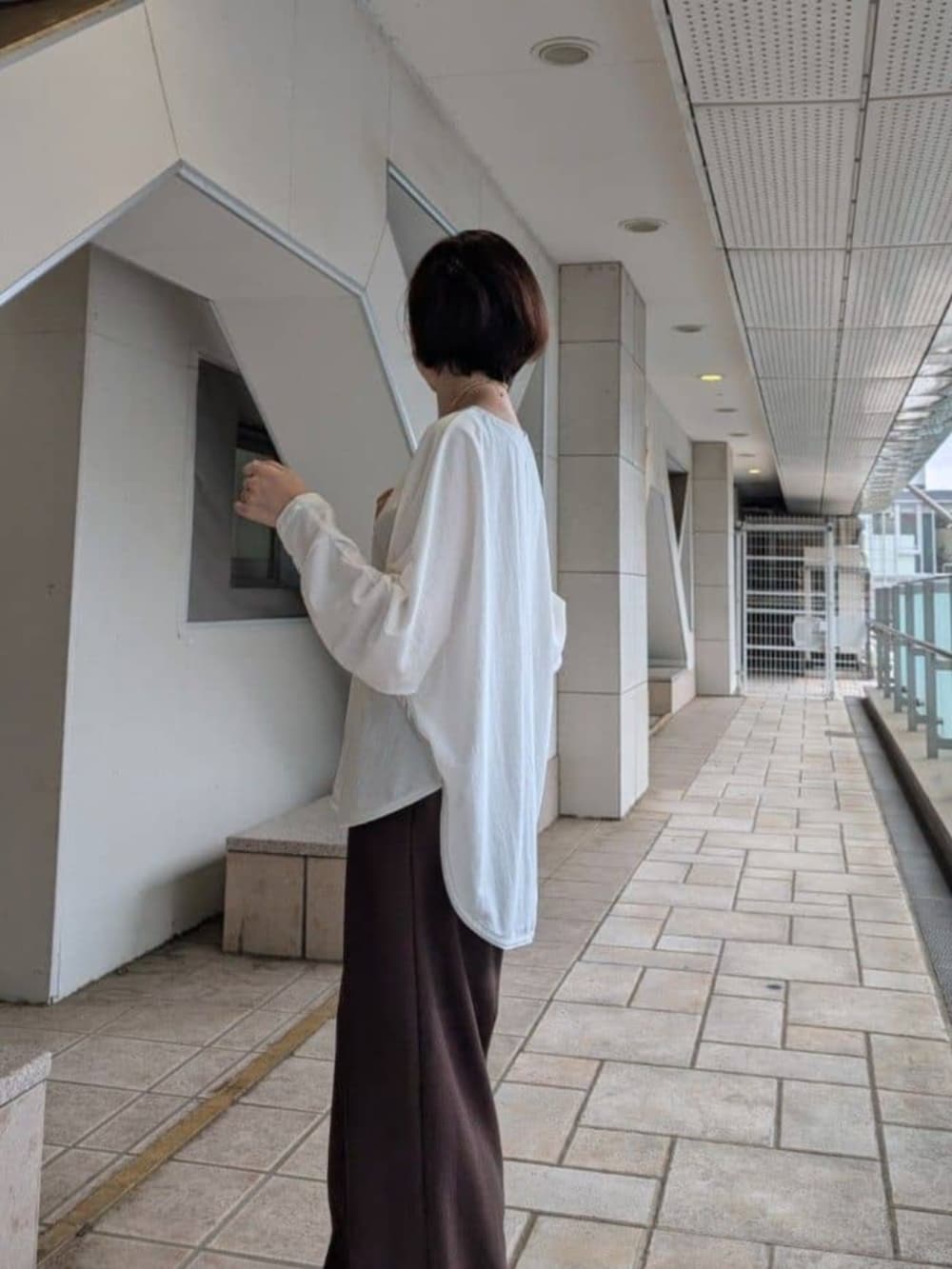 グレー系のハンドバッグ、ホワイト系のTシャツ/カットソー、ブラウン系のその他パンツを着用したレディースの夏コーディネートの6枚目の写真