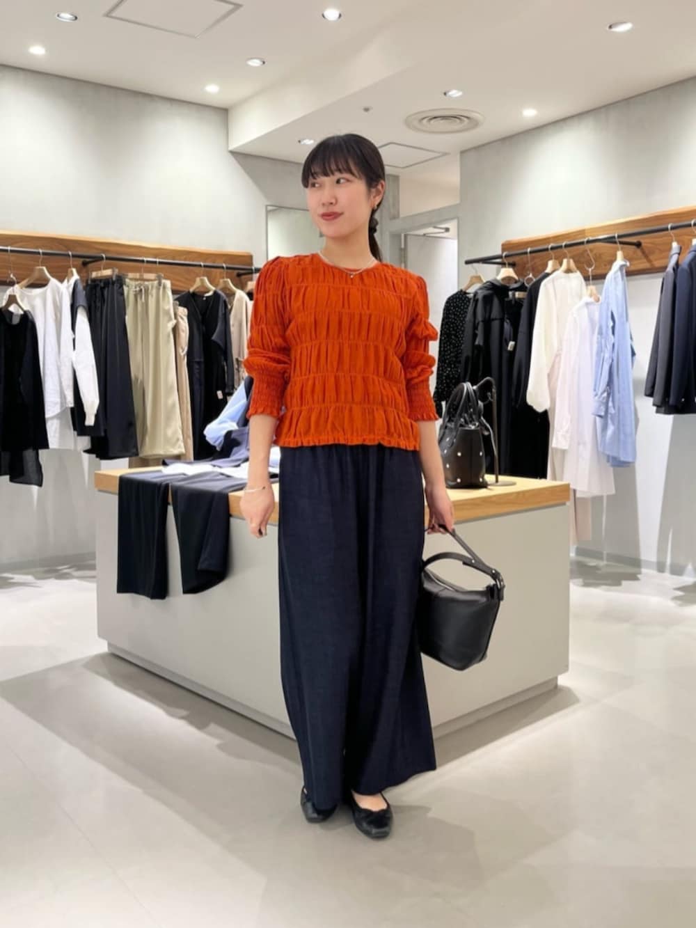 ブルー系のその他パンツ、オレンジ系のシャツ/ブラウスを着用したレディースの春コーディネートの2枚目の写真