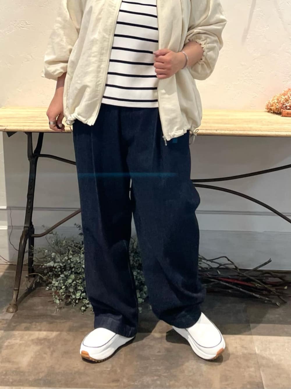 ホワイト系のノーカラージャケット、ホワイト系のニット/セーター、ブルー系のデニムパンツを着用したレディースの冬コーディネートの7枚目の写真