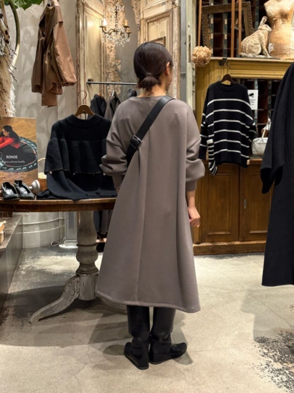 ブラウン系のワンピース、ブラック系のショルダーバッグ、シルバー系のネックレスを着用したレディースの冬コーディネートの6枚目の写真