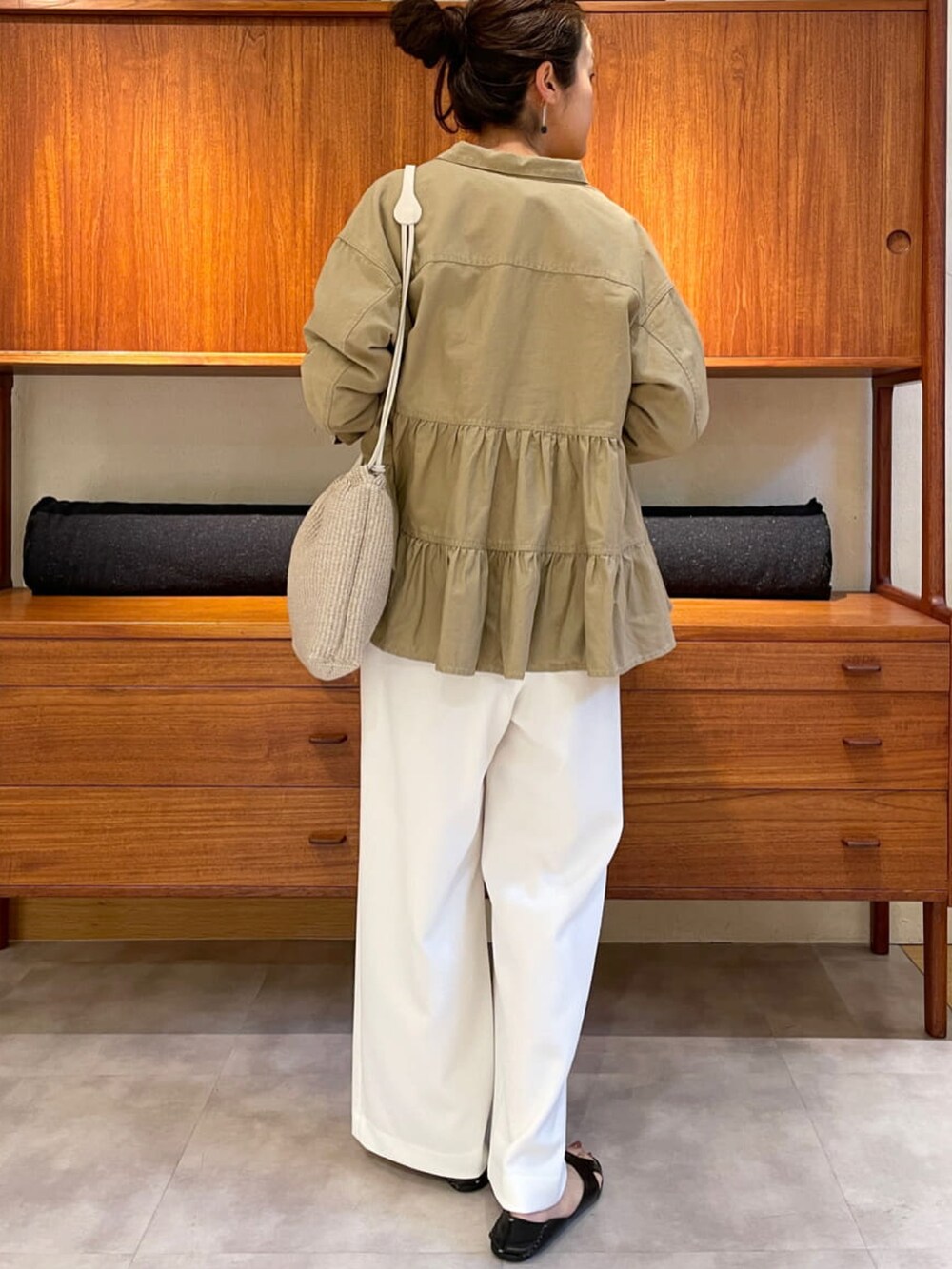 ベージュ系のシャツ/ブラウス、ブラック系のニット/セーター、ホワイト系のその他パンツを着用したレディースの春コーディネートの3枚目の写真