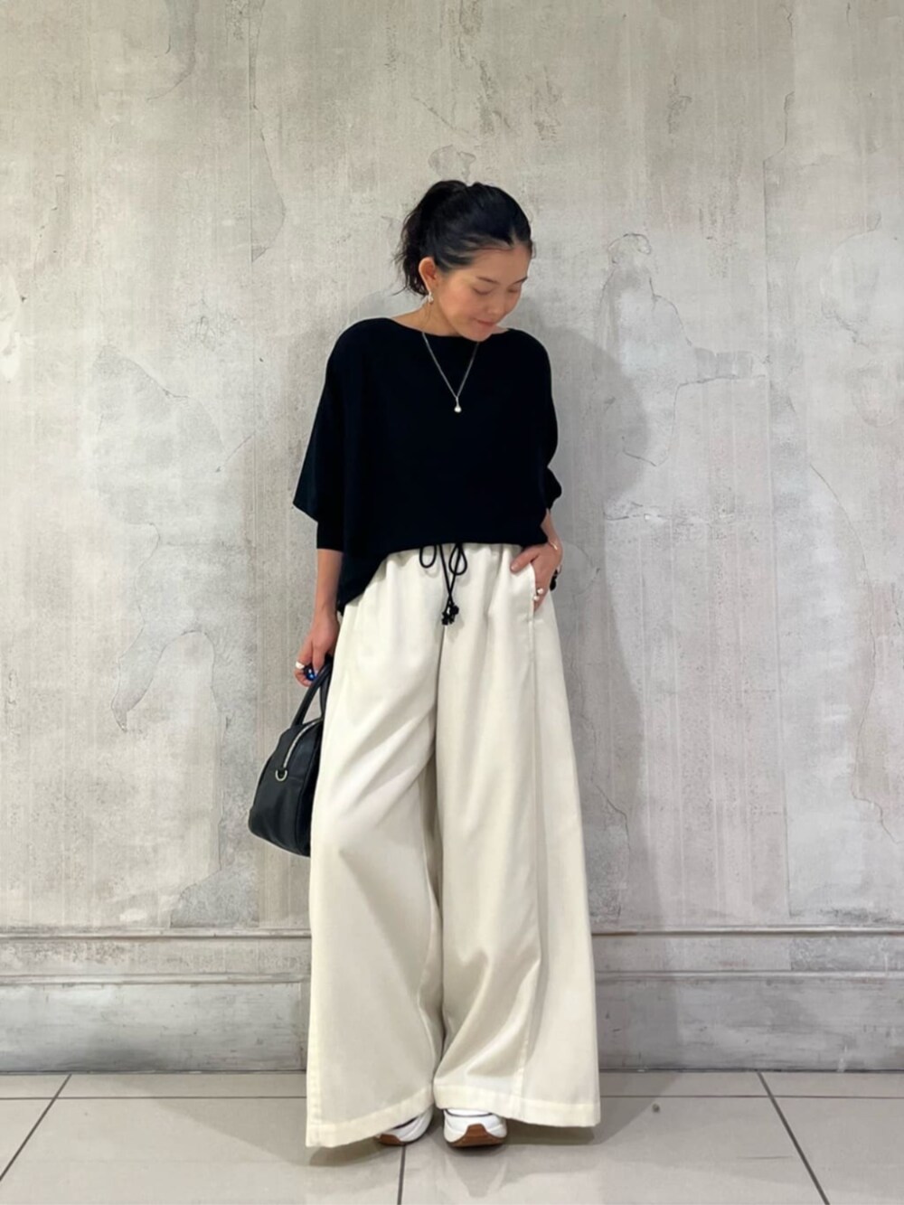 ブラック系のニット/セーター、ホワイト系のその他パンツを着用したレディースの冬コーディネートの5枚目の写真