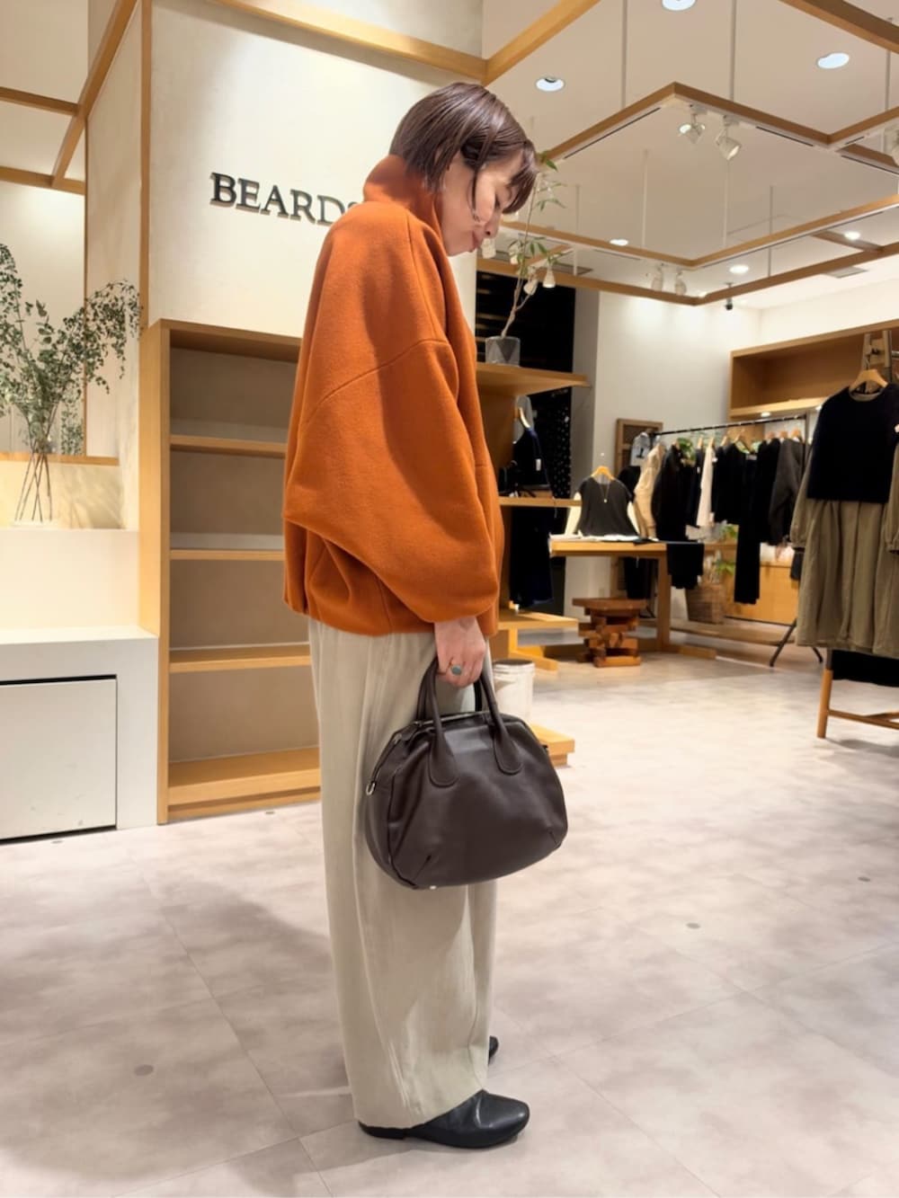 グレー系のその他パンツ、オレンジ系のその他アウターを着用したレディースの秋コーディネートの6枚目の写真