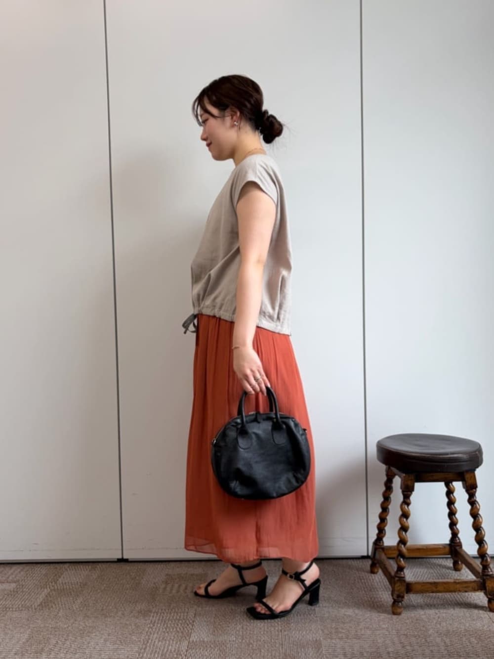 ブラック系のボストンバッグ、オレンジ系のその他パンツ、ベージュ系のシャツ/ブラウスを着用したレディースの冬コーディネートの2枚目の写真