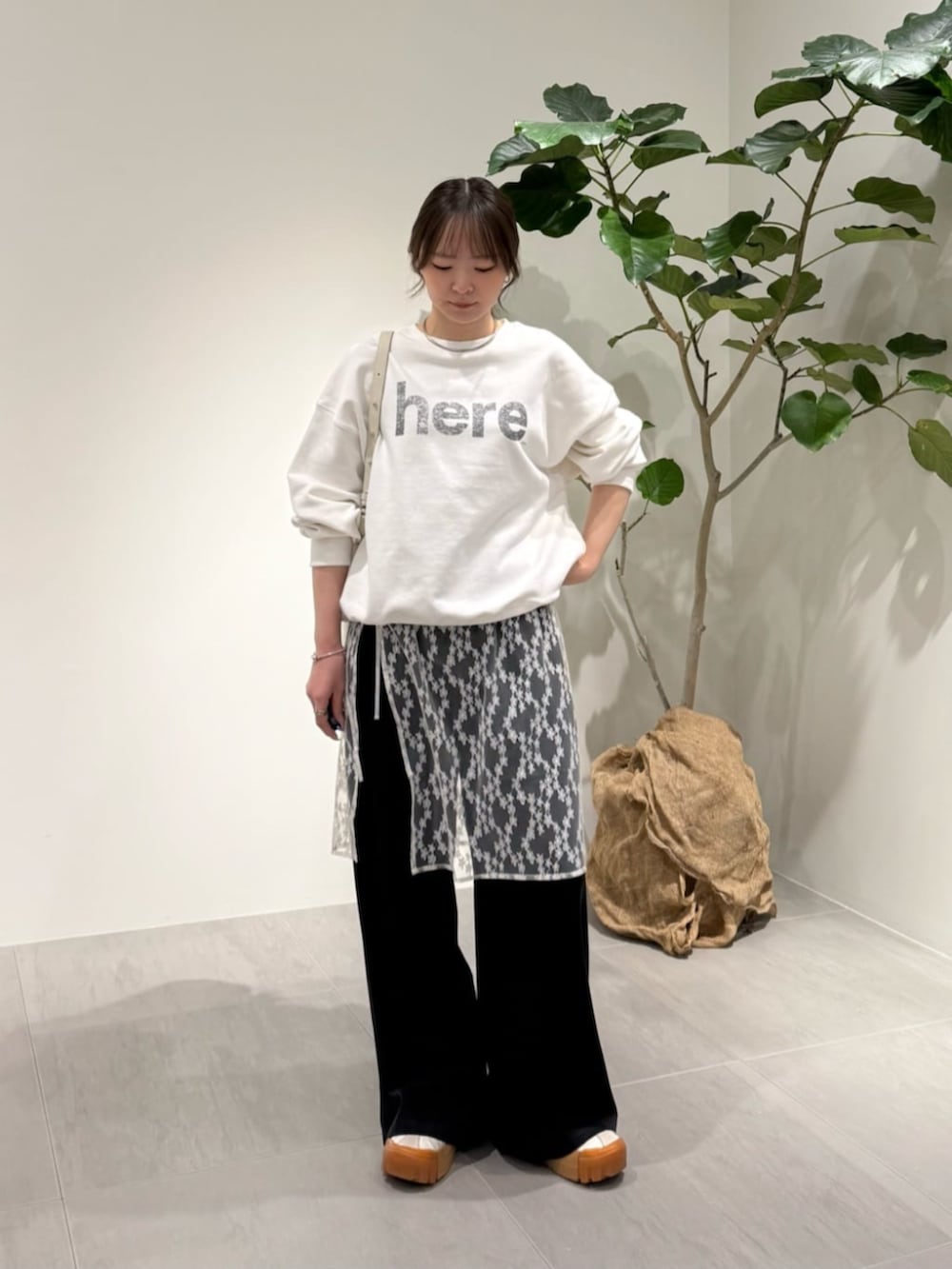 ブラック系のその他パンツ、グレー系のニット/セーター、ホワイト系のTシャツ/カットソーを着用したレディースの春コーディネートの2枚目の写真