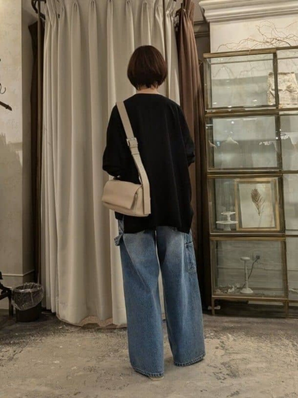 ホワイト系のタンクトップ、ベージュ系のショルダーバッグ、ブルー系のその他パンツを着用したレディースの春コーディネートの3枚目の写真