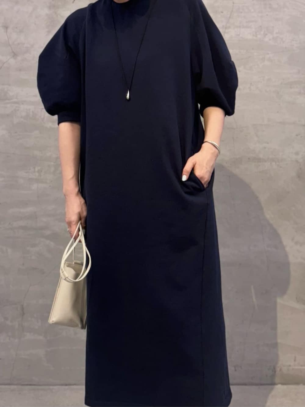 ホワイト系のショルダーバッグ、ブルー系のワンピースを着用したレディースの冬コーディネートの9枚目の写真