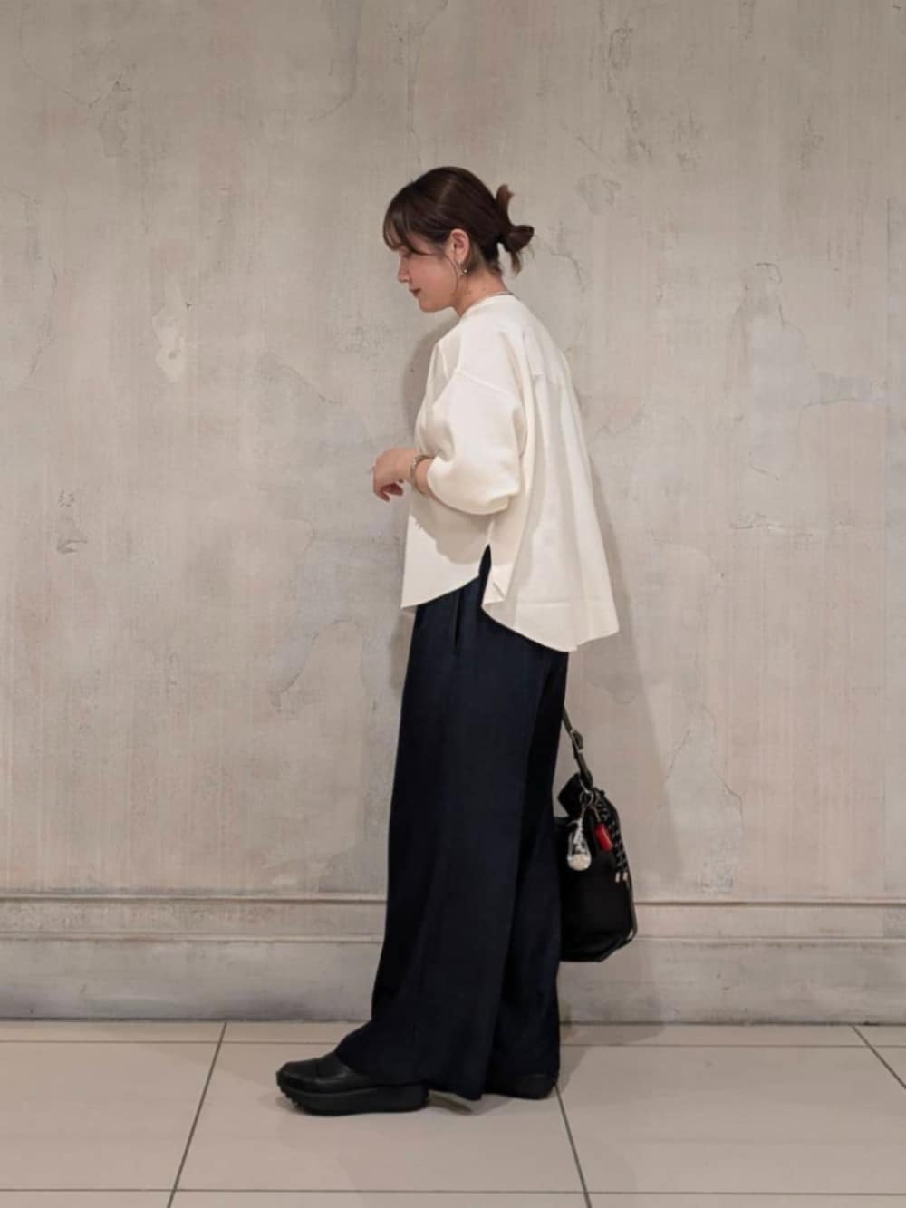 ブルー系のその他パンツ、ブラック系のショルダーバッグ、ホワイト系のTシャツ/カットソーを着用したレディースの春コーディネートの6枚目の写真