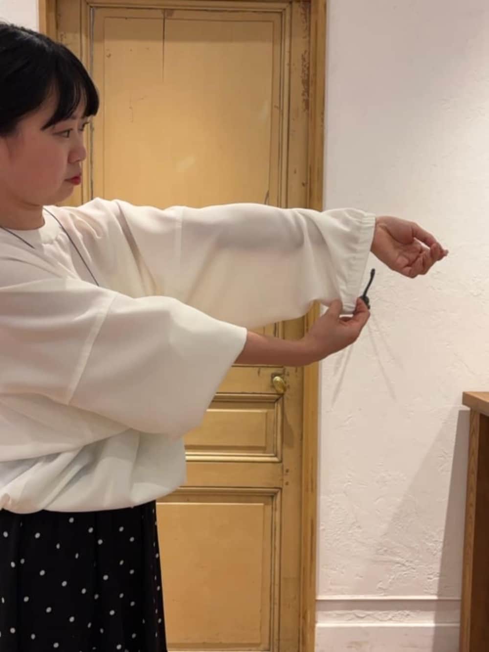 ブラック系のスカート、ピンク系のハンドバッグ、ホワイト系のシャツ/ブラウスを着用したレディースの冬コーディネートの6枚目の写真