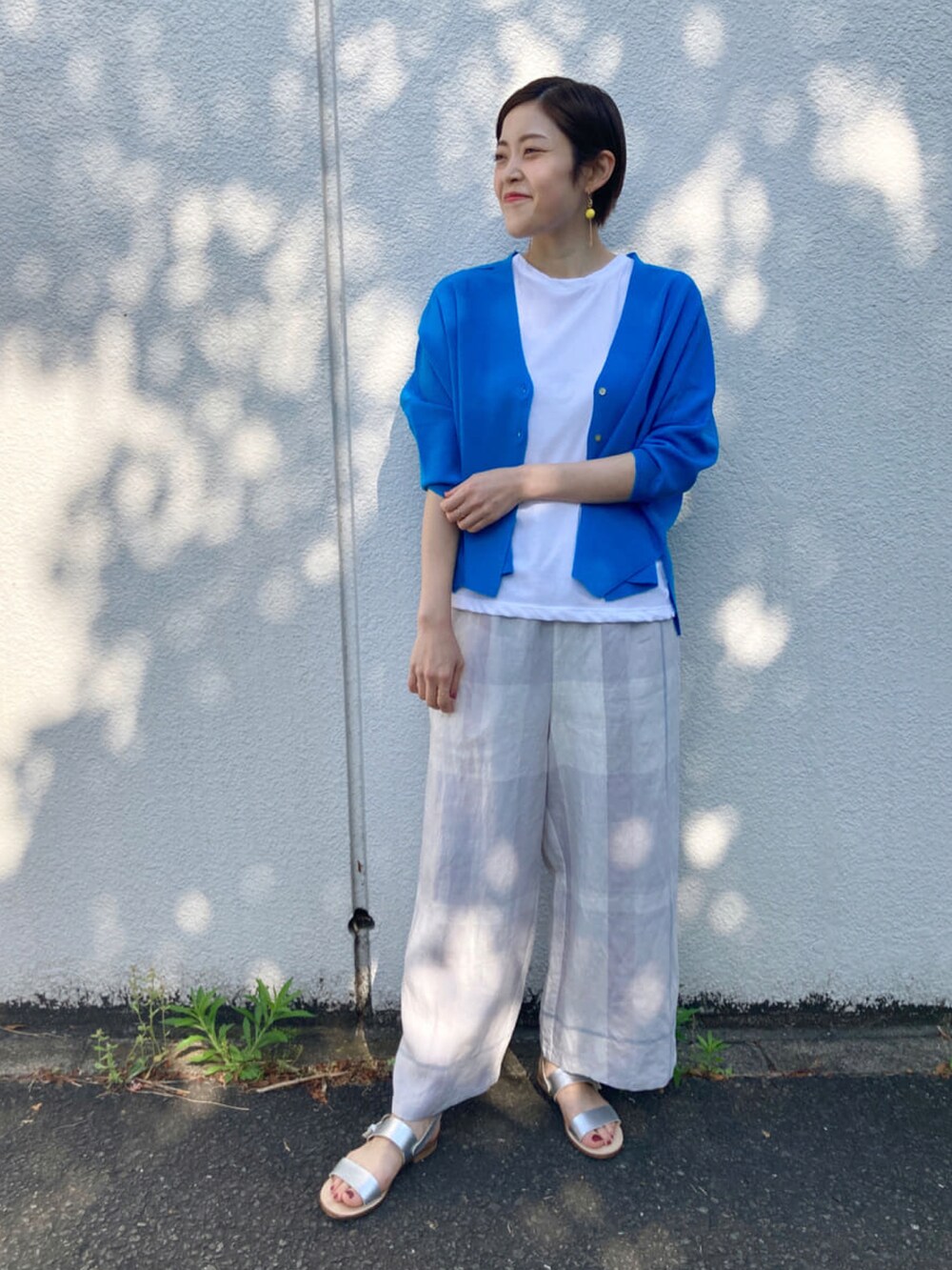 グレー系のその他パンツ、ホワイト系のTシャツ/カットソー、シルバー系のサンダルを着用したレディースの春コーディネートの3枚目の写真