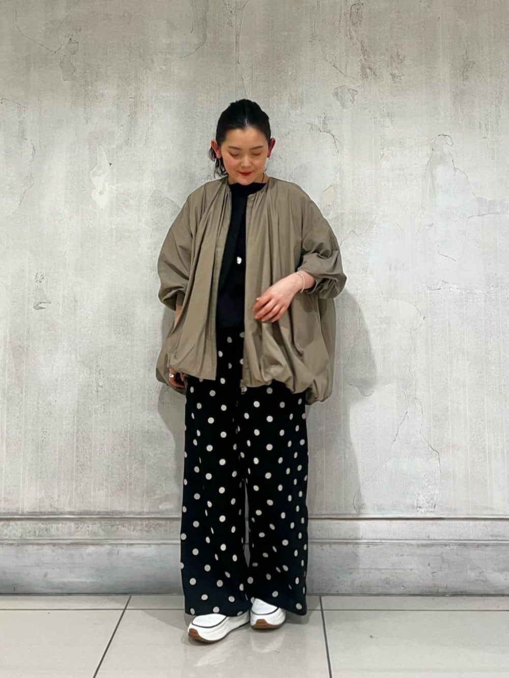 ブラック系のハンドバッグ、ブラック系のその他パンツ、ブラウン系のブルゾンを着用したレディースの春コーディネートの3枚目の写真