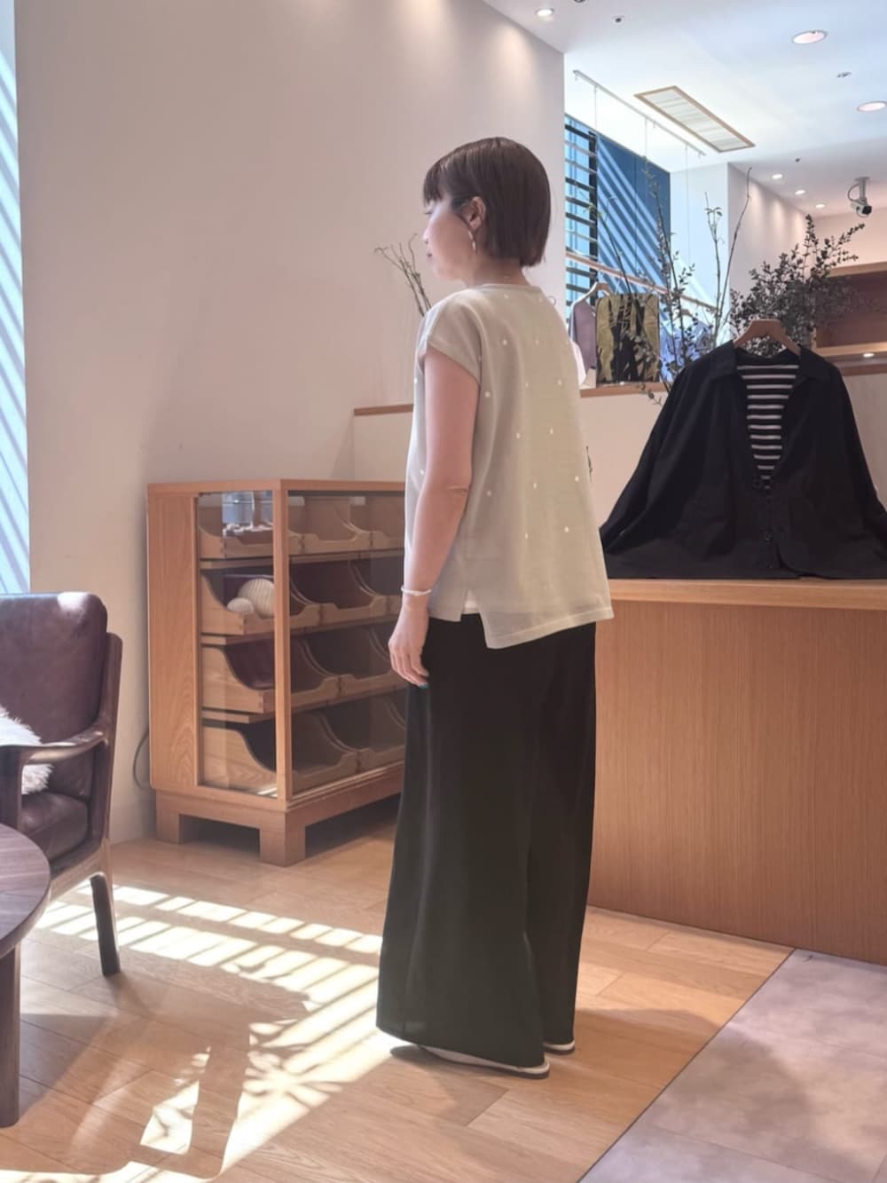 シルバー系のショルダーバッグ、ブラック系のその他パンツ、グレー系のニット/セーターを着用したレディースの春コーディネートの2枚目の写真