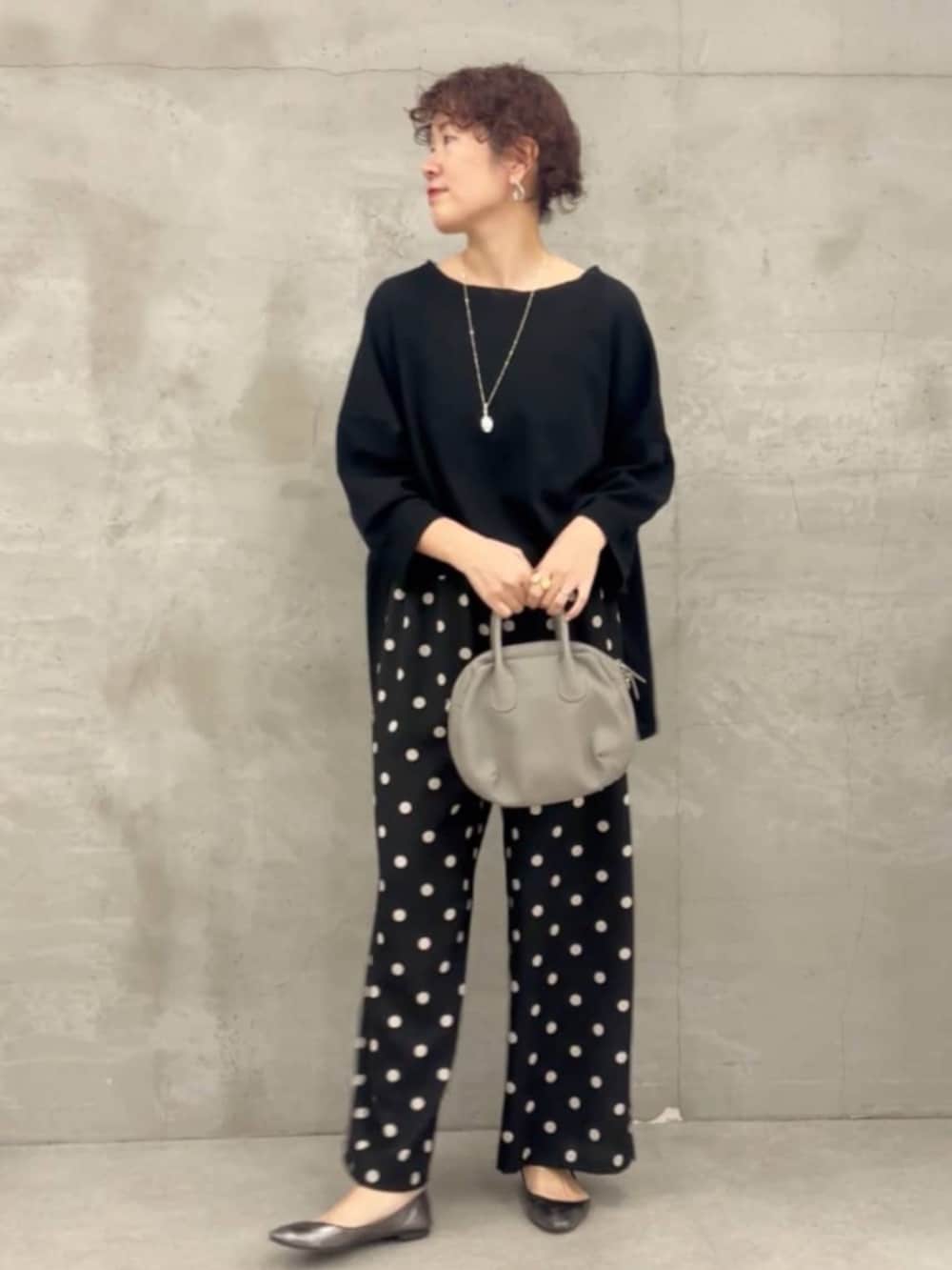 グレー系のボストンバッグ、ブラック系のTシャツ/カットソー、ブラック系のその他パンツを着用したレディースの冬コーディネートの2枚目の写真