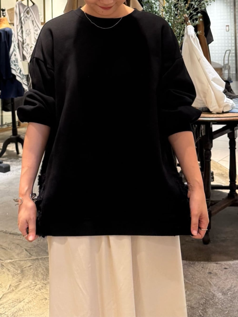 ブラック系のトートバッグ、ベージュ系のスカート、ブラック系のTシャツ/カットソーを着用したレディースの秋コーディネートの5枚目の写真