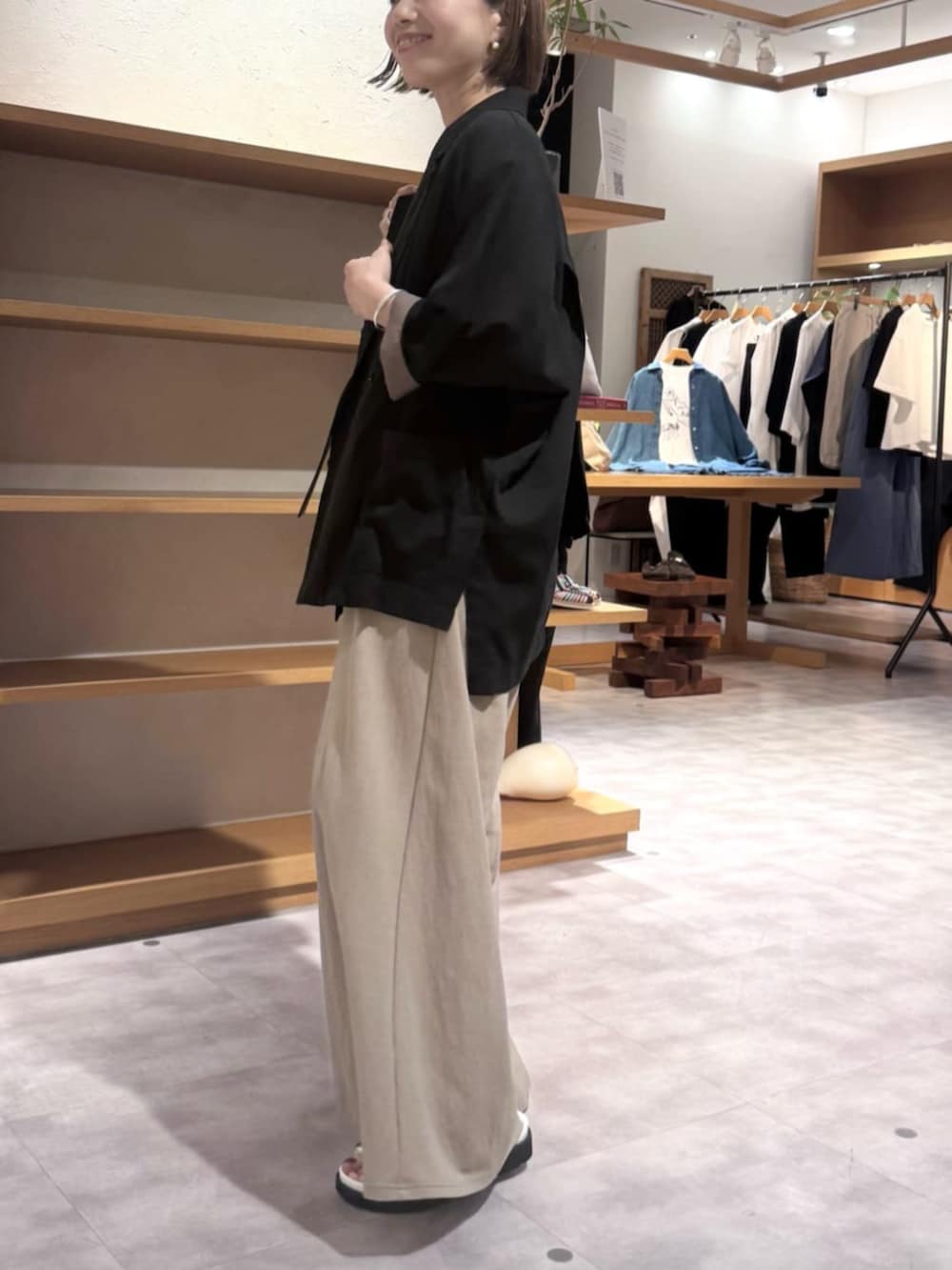 ブラック系のテーラードジャケット、ベージュ系のその他パンツ、ホワイト系のサンダルを着用したレディースの春コーディネートの5枚目の写真