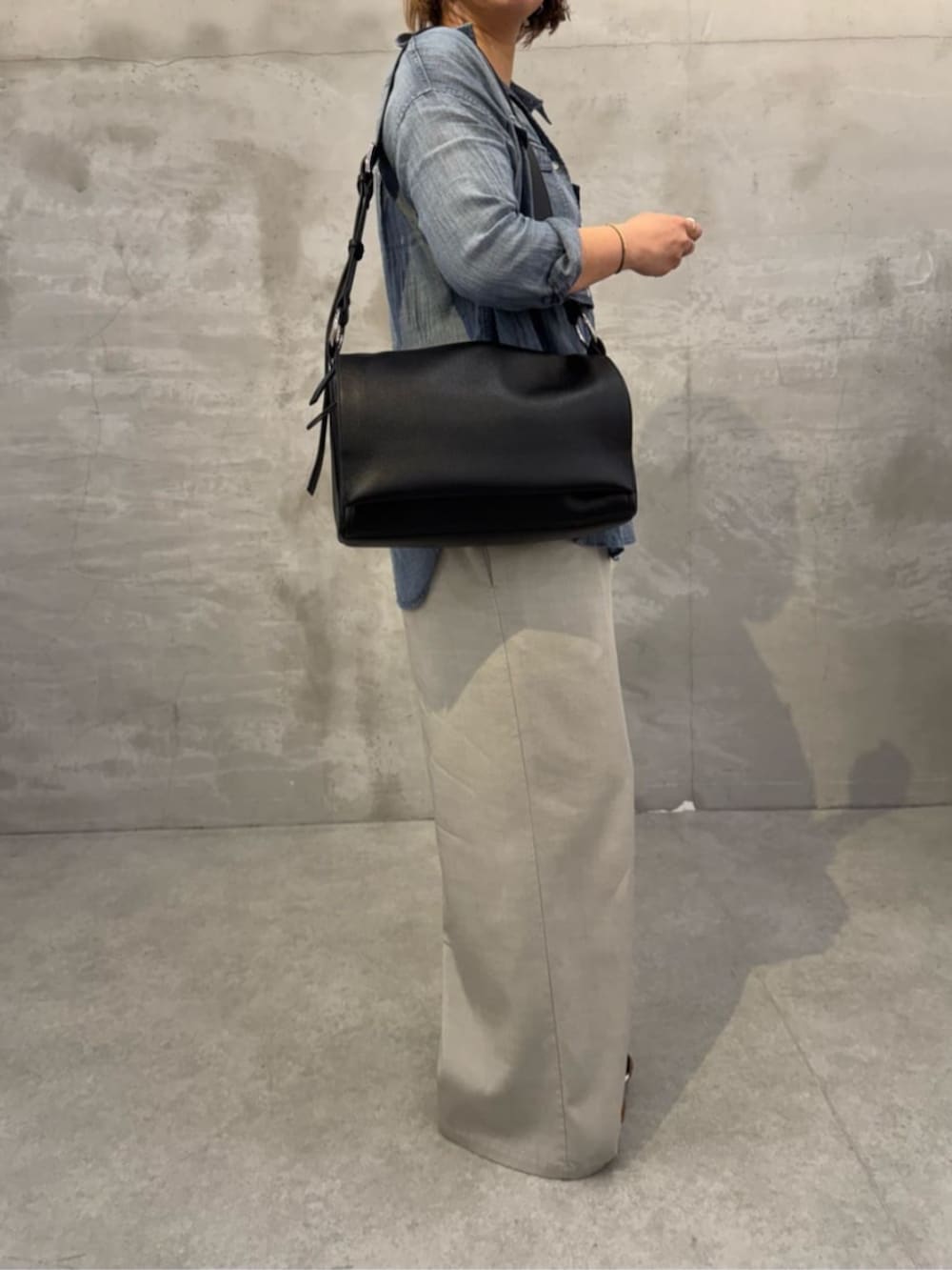 ブルー系のシャツ/ブラウス、ブラック系のショルダーバッグを着用したレディースの春コーディネートの4枚目の写真