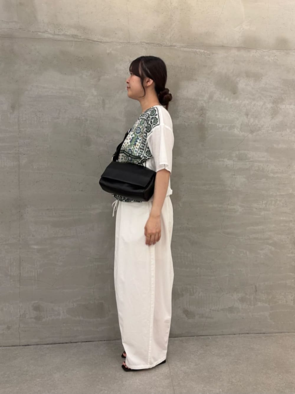 ブラック系のショルダーバッグ、ホワイト系のTシャツ/カットソーを着用したレディースの春コーディネートの3枚目の写真