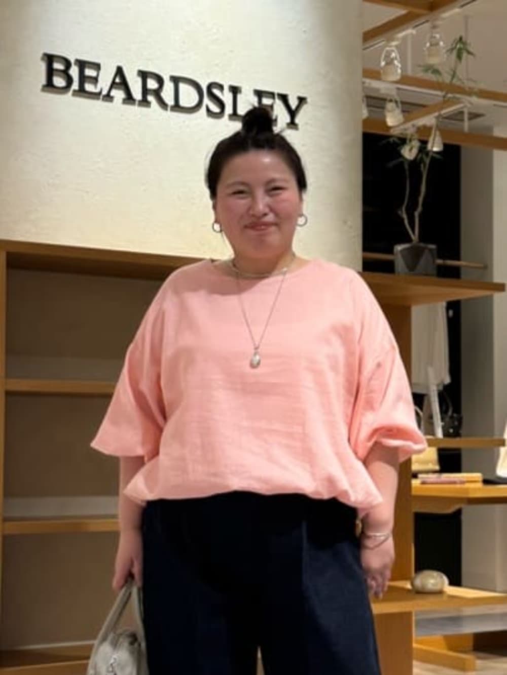 グレー系のボストンバッグ、ピンク系のシャツ/ブラウス、ホワイト系のサンダルを着用したレディースの冬コーディネートの8枚目の写真