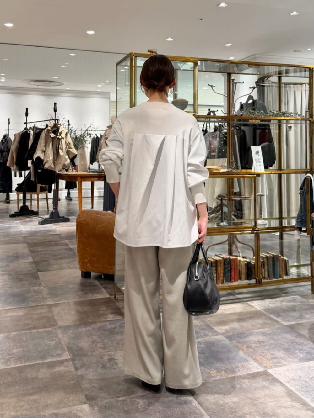 ブラック系のボストンバッグ、ホワイト系のニット/セーター、グレー系のその他パンツを着用したレディースの冬コーディネートの3枚目の写真