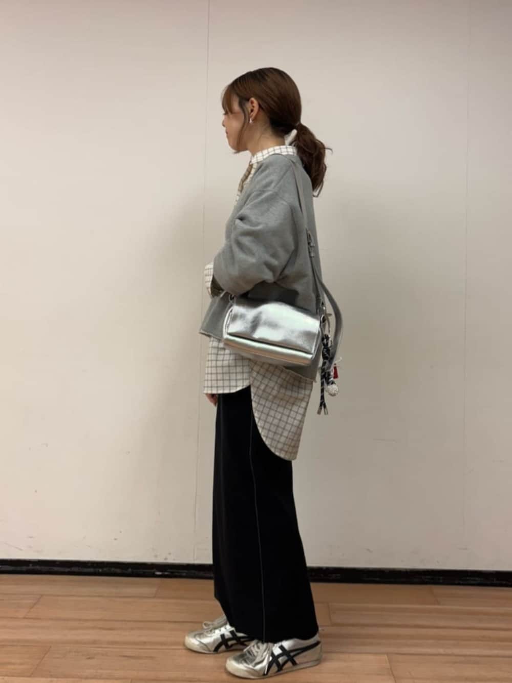 シルバー系のショルダーバッグ、ホワイト系のシャツ/ブラウス、ブラック系のスカートを着用したレディースの冬コーディネートの3枚目の写真