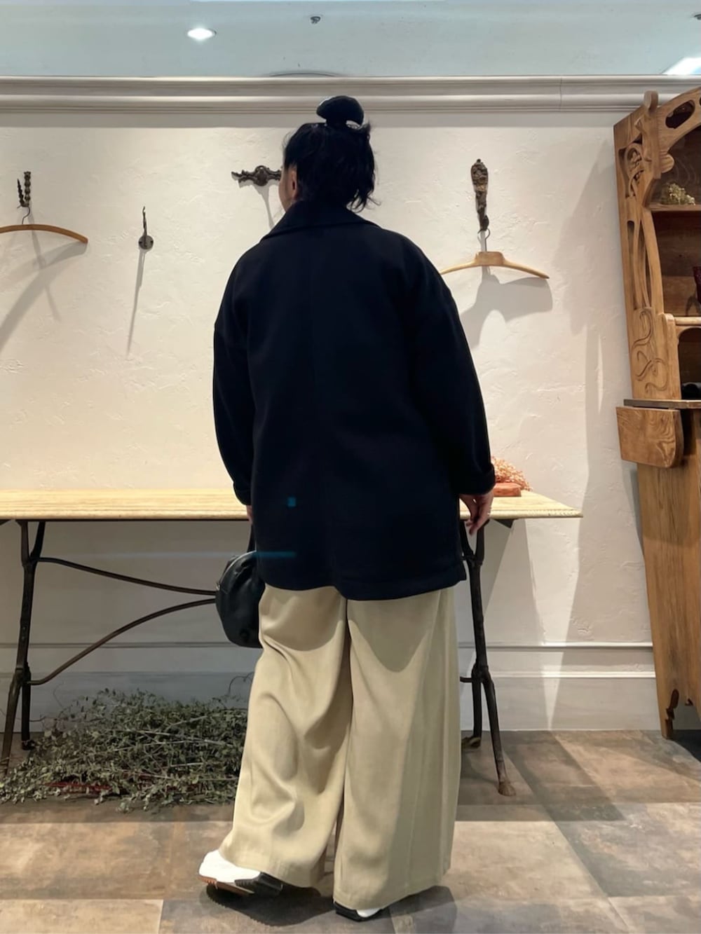 ブラック系のボストンバッグ、ベージュ系のその他パンツ、ブラック系のピーコートを着用したレディースの冬コーディネートの3枚目の写真