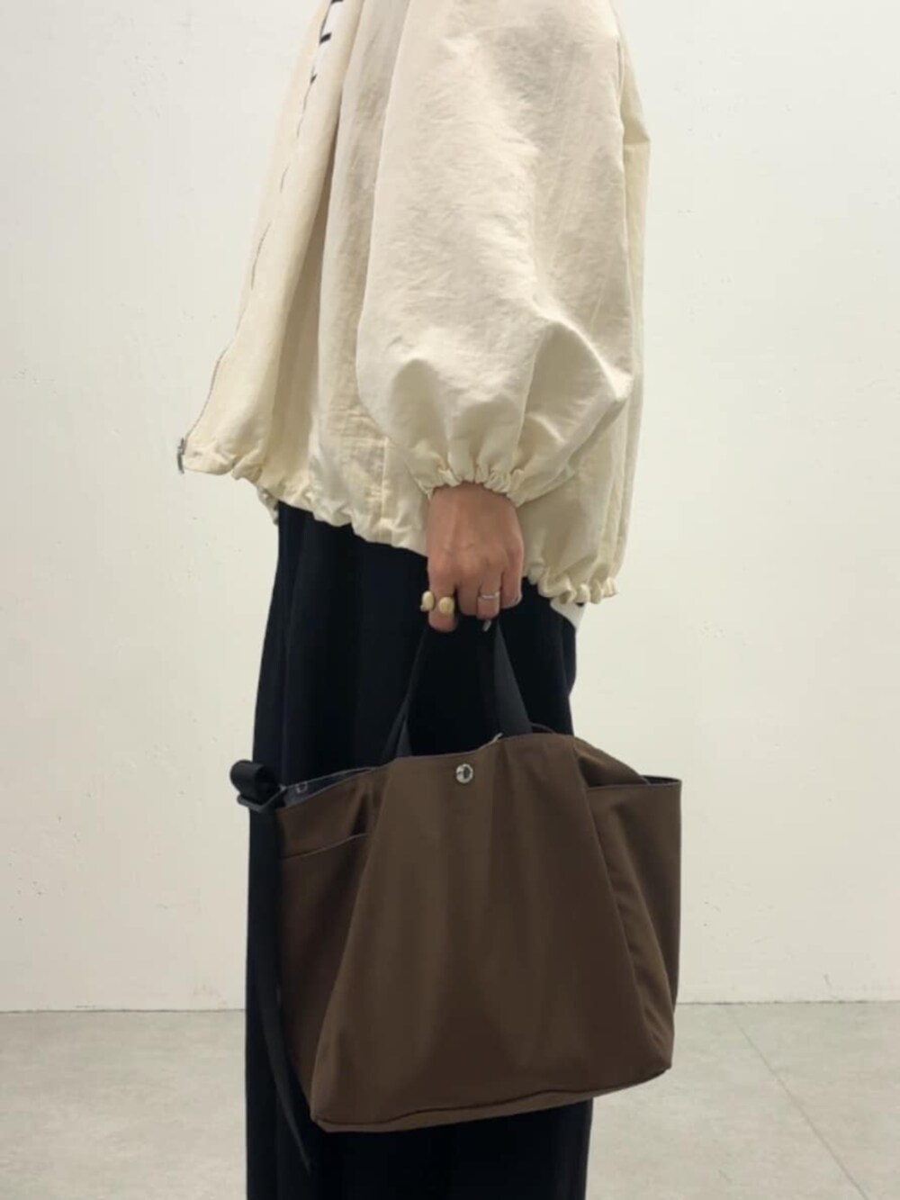 ホワイト系のノーカラージャケット、ブラック系のその他パンツ、ホワイト系のニット/セーターを着用したレディースの冬コーディネートの4枚目の写真