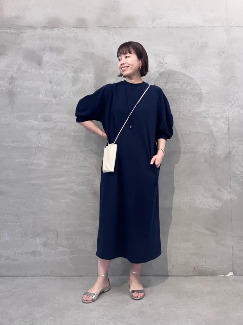 ホワイト系のショルダーバッグ、ブルー系のワンピースを着用したレディースの冬コーディネートの2枚目の写真