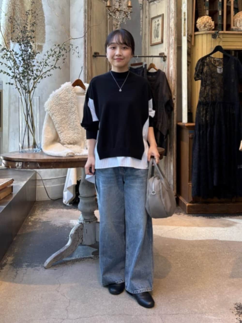 ブルー系のデニムパンツ、ブラック系のニット/セーターを着用したレディースの秋コーディネートの5枚目の写真
