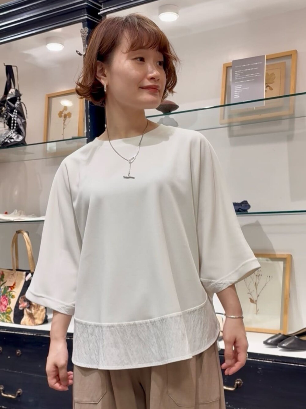 ベージュ系のその他パンツ、ブラック系のトートバッグ、ホワイト系のTシャツ/カットソーを着用したレディースの春コーディネートの7枚目の写真