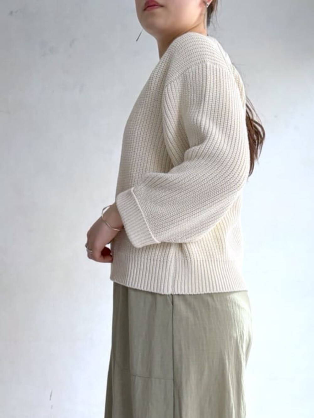 ホワイト系のニット/セーター、グリーン系のその他パンツ、ブラック系のトートバッグを着用したレディースの冬コーディネートの3枚目の写真