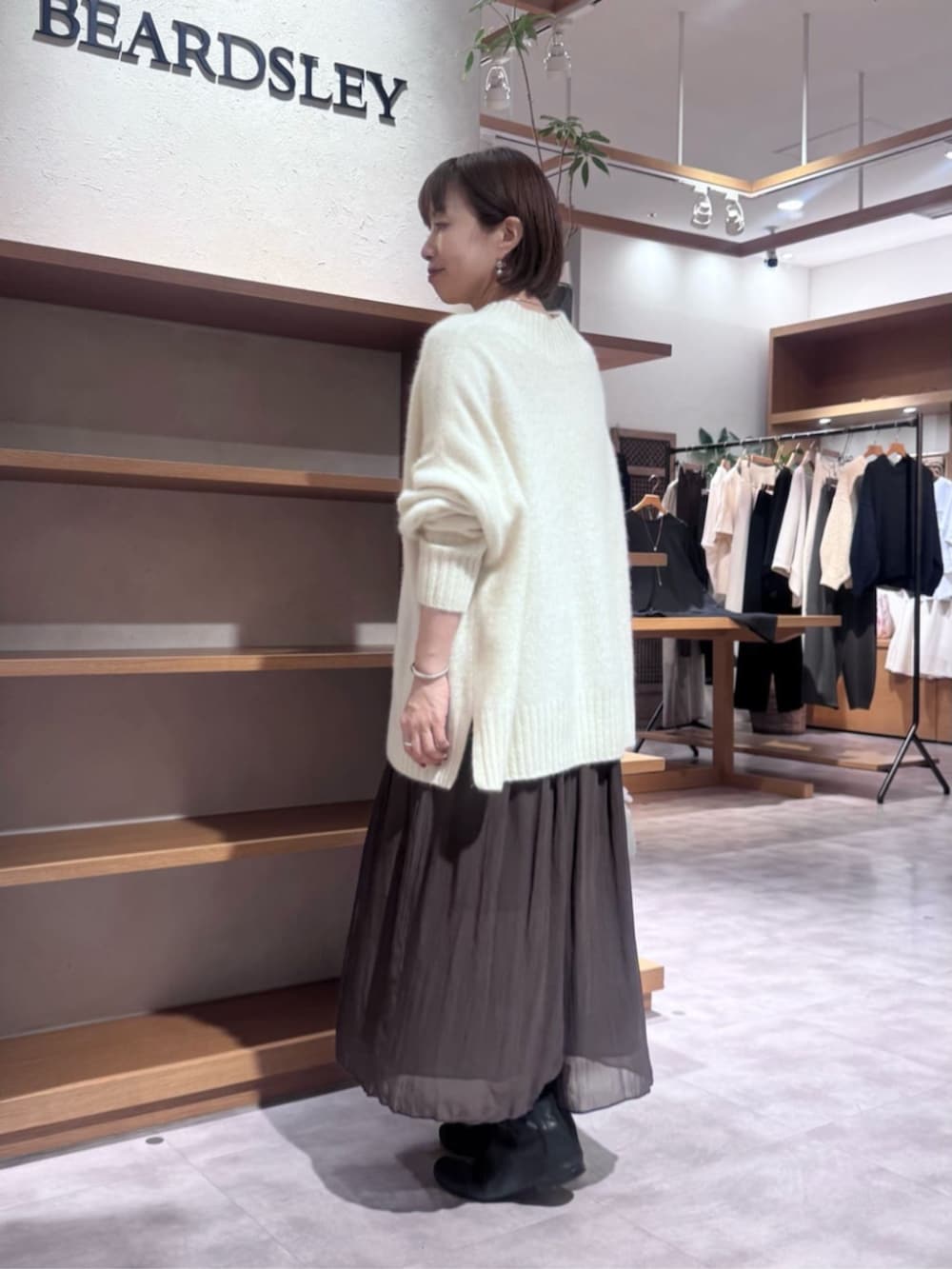 グレー系のボストンバッグ、ホワイト系のニット/セーター、ブラウン系のその他パンツを着用したレディースの冬コーディネートの4枚目の写真