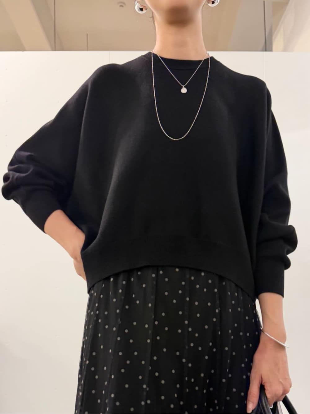 ブラック系のスカート、ブラック系のブーツ、ブラック系のニット/セーターを着用したレディースの夏コーディネートの9枚目の写真