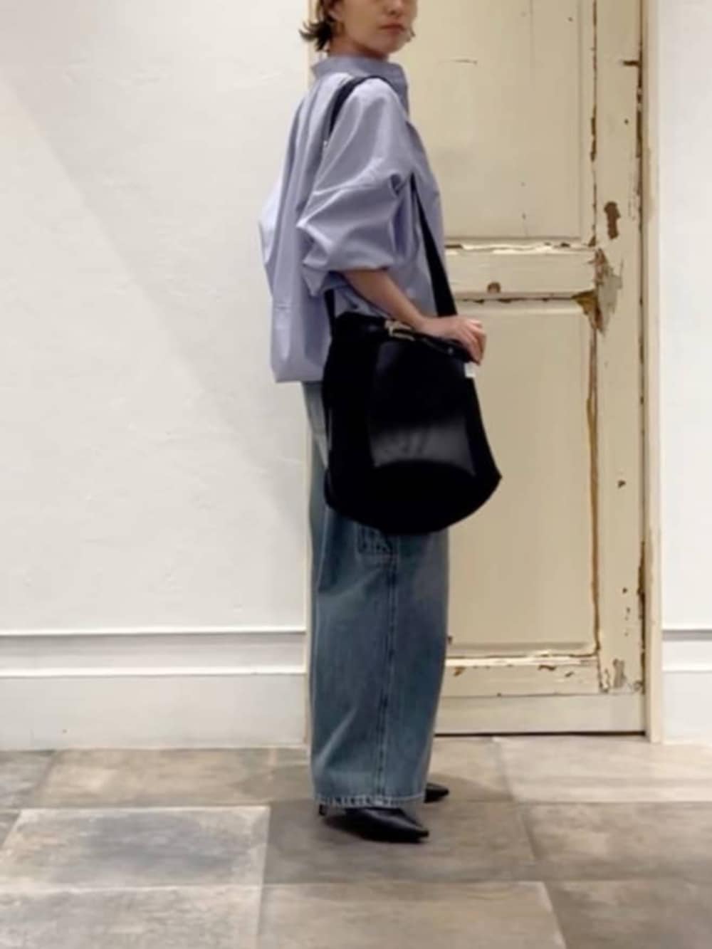 ブラック系のトートバッグ、ブルー系のその他パンツ、ブルー系のシャツ/ブラウスを着用したレディースの冬コーディネートの2枚目の写真