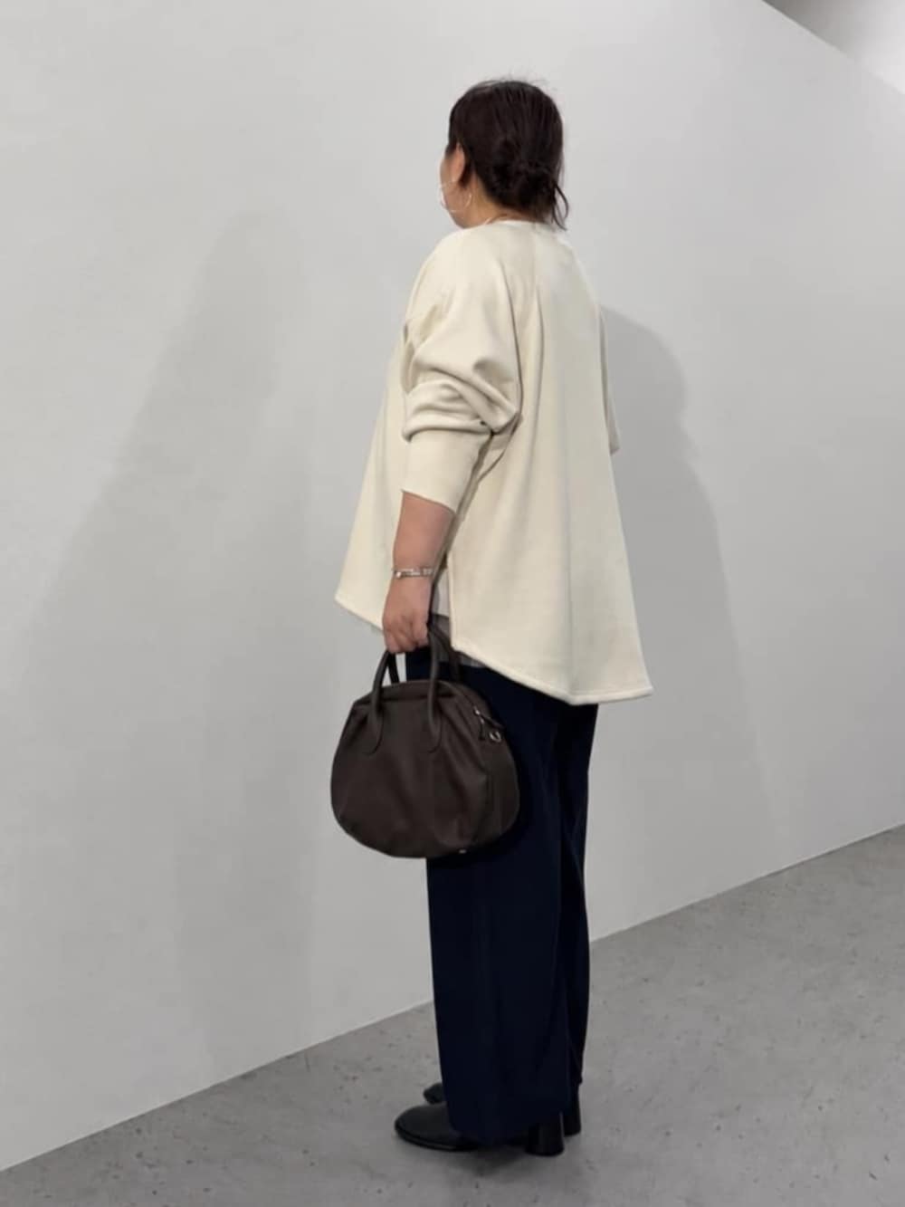 ブルー系のその他パンツ、ブラウン系のトートバッグ、ホワイト系のTシャツ/カットソーを着用したレディースの秋コーディネートの5枚目の写真
