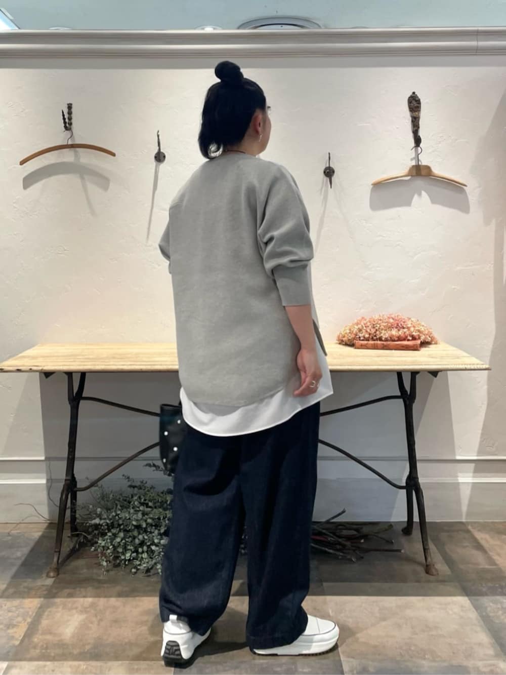 ホワイト系のスニーカー、ホワイト系のシャツ/ブラウス、グレー系のニット/セーターを着用したレディースの冬コーディネートの3枚目の写真