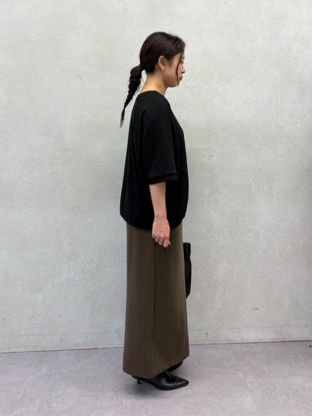 ブラック系のトートバッグ、ブラック系のTシャツ/カットソー、ブラウン系のスカートを着用したレディースの夏コーディネートの3枚目の写真