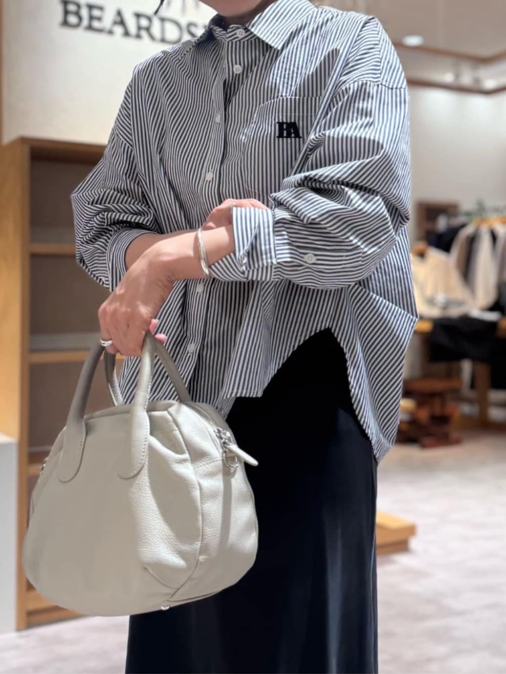 ブラック系のスカート、グレー系のボストンバッグ、ブルー系のシャツ/ブラウスを着用したレディースの冬コーディネートの4枚目の写真