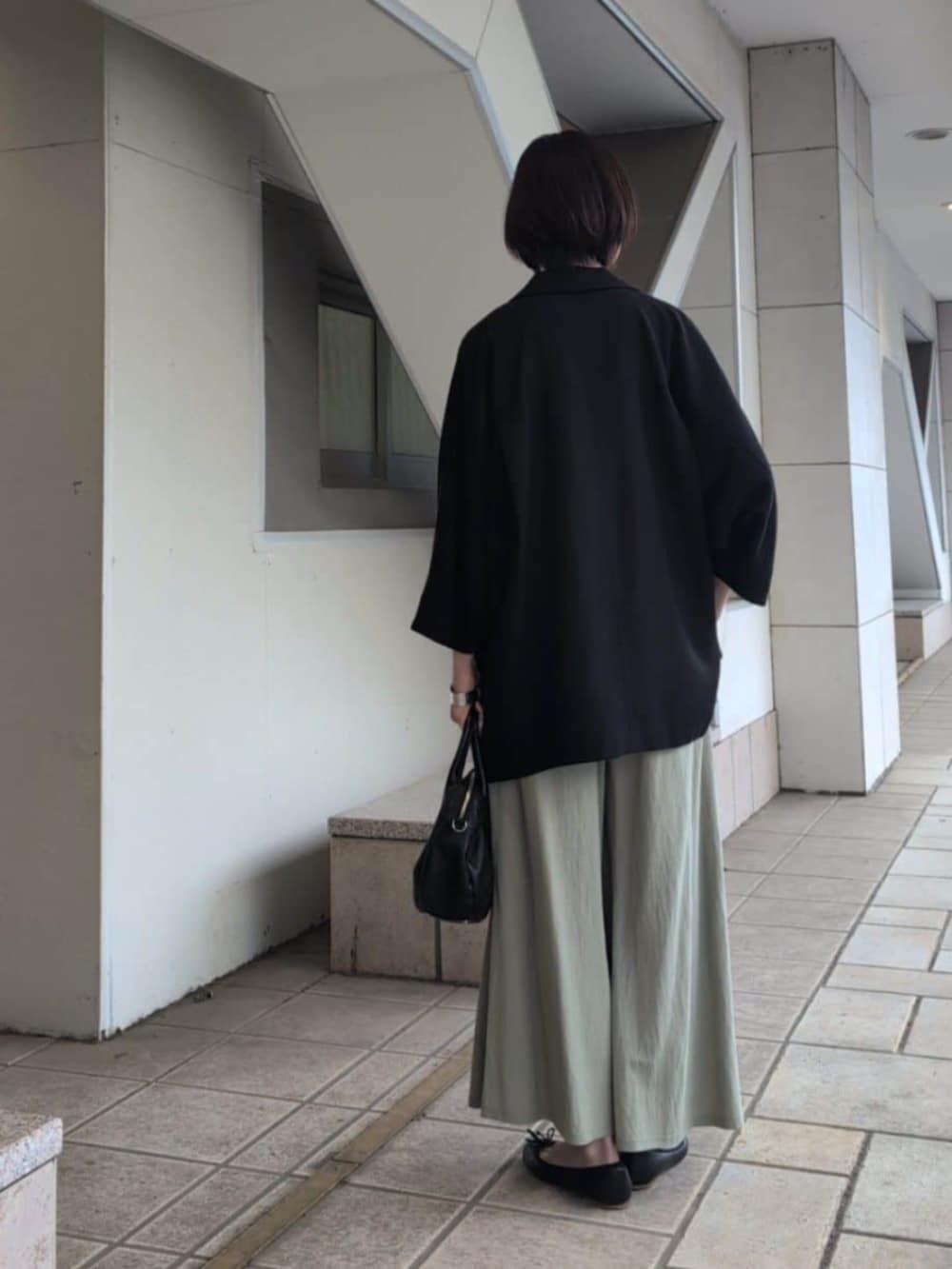 ブラック系のボストンバッグ、グリーン系のその他パンツ、ホワイト系のTシャツ/カットソーを着用したレディースの春コーディネートの3枚目の写真