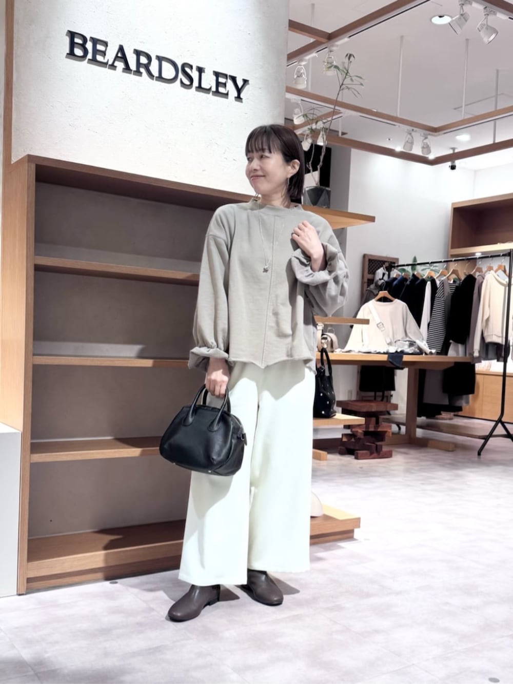 ブラック系のボストンバッグ、ブラウン系のTシャツ/カットソー、ホワイト系のその他パンツを着用したレディースの冬コーディネートの5枚目の写真