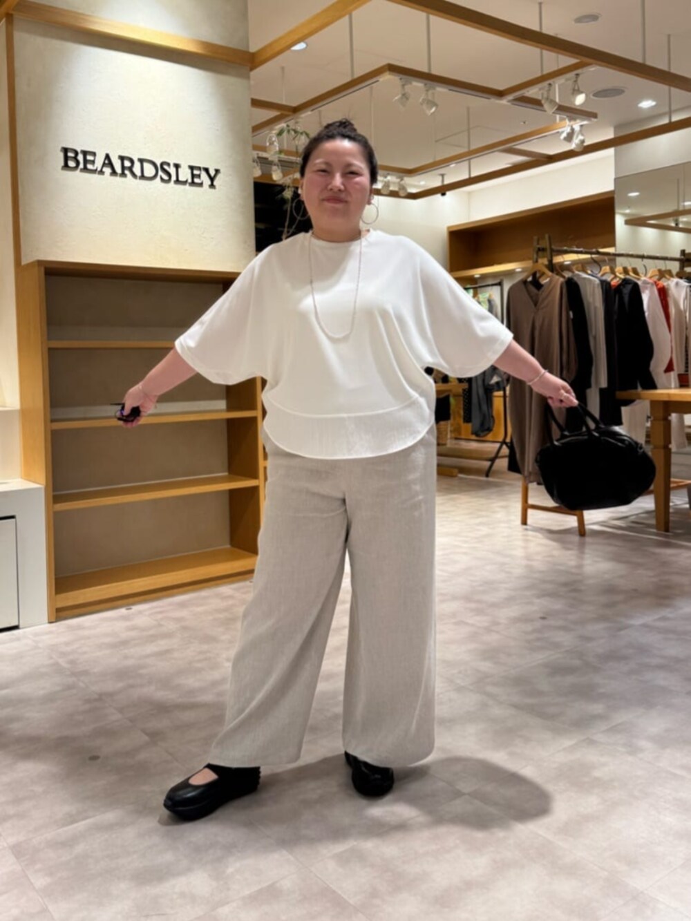 ブラック系のボストンバッグ、ベージュ系のその他パンツ、ホワイト系のTシャツ/カットソーを着用したレディースの春コーディネートの2枚目の写真