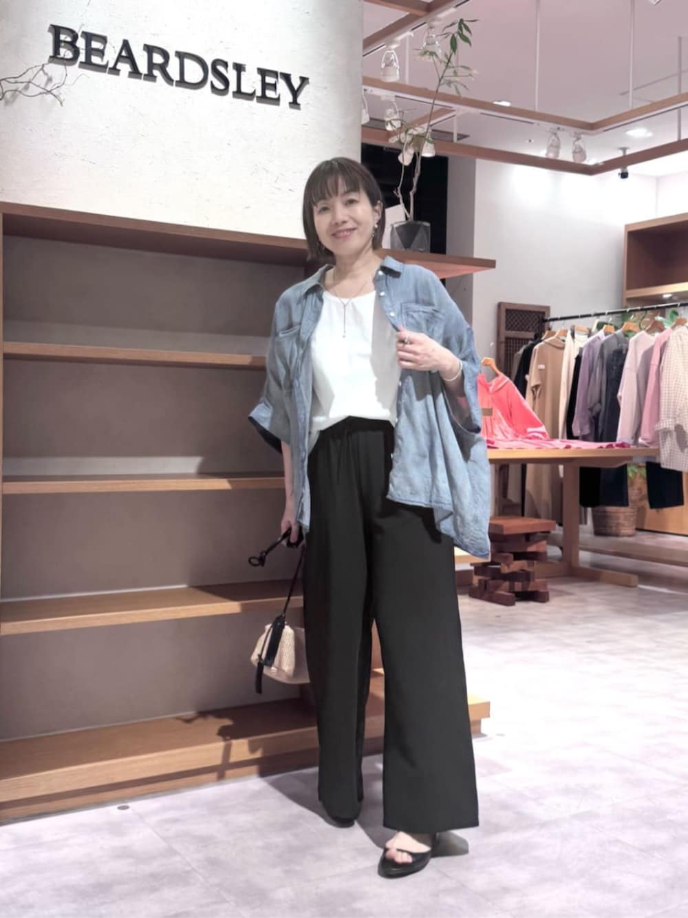 ブラック系のその他パンツ、ブルー系のシャツ/ブラウスを着用したレディースの春コーディネートの7枚目の写真