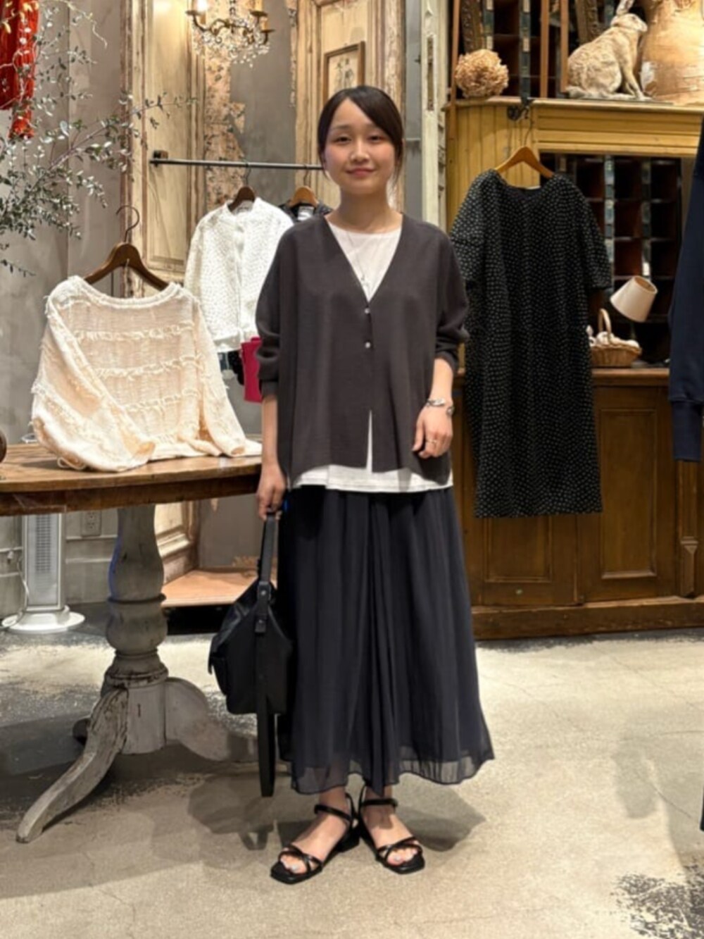 ブラック系のその他パンツ、ホワイト系のシャツ/ブラウス、グレー系のカーディガン/ボレロを着用したレディースの春コーディネートの3枚目の写真